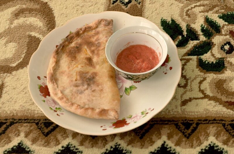 In Usbekistan werden die mit Kürbis- und Zwiebelstücken gefüllten Teigtaschen mit Tomatensauce serviert. – Bild: Elephant Doc