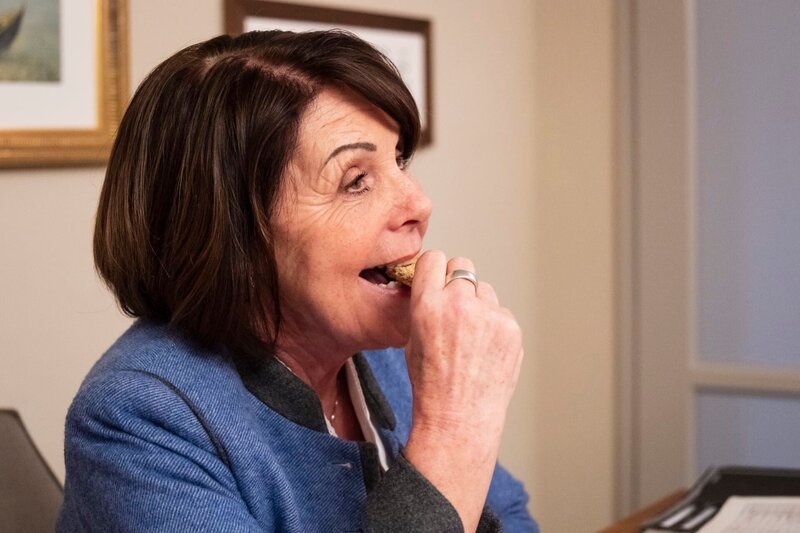 Rosi (Brigitte Walbrun) lässt sich ganz ungeniert einen Keks schmecken, ohne zu ahnen, dass es sich um einen Haschkeks handelt. – Bild: BR/​Lena Semmelroggen