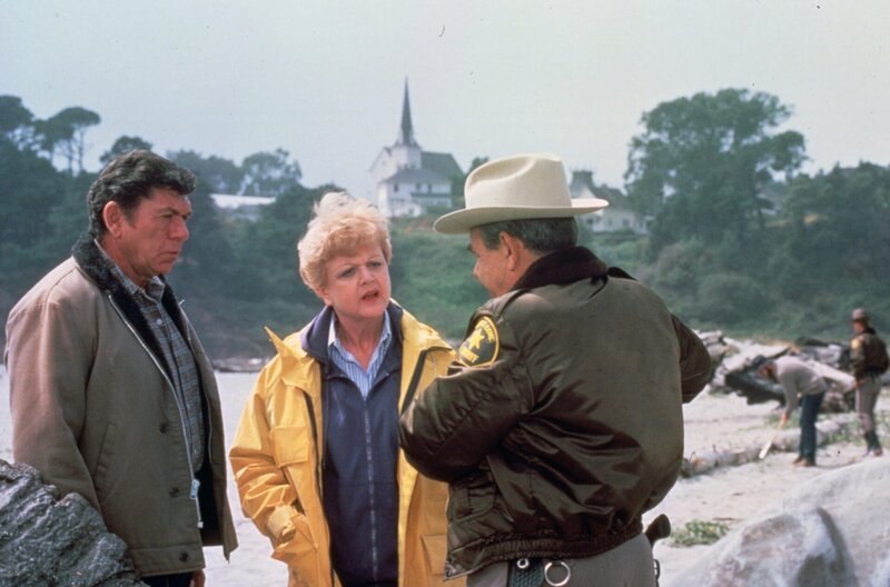 Jessica (Angela Lansbury, M.) bekommt Besuch von ihrem alten Freund Ethan Cragg (Claude Akins, l.). Von Sheriff Amos Tupper (Tom Bosley, r.) erfahren sie von dem Unglück, das sich während eines Unwetters zugetragen hat. – Bild: Universal Pictures