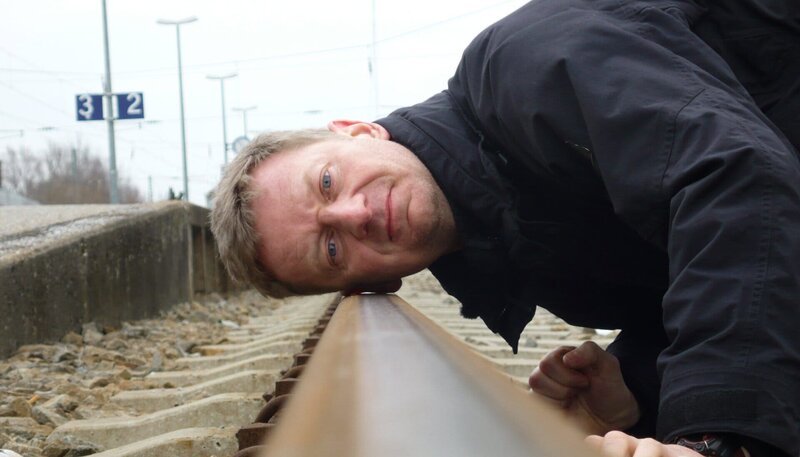 Michael Kessler hat weder einen Auftrag, noch ein Ziel, denn er ist auf der Flucht. Nachdem er aus Versehen den gesamten Sendebetrieb des rbb lahmlegt, steigt er in den nächstbesten Zug – und dann wieder in den nächsten. – Bild: rbb/​Roland Albrecht