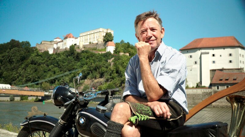 Stofferl Well auf seinem Motorrad vor der Feste Oberhaus in Passau. – Bild: BR/​Pius Neumaier/​megaherz