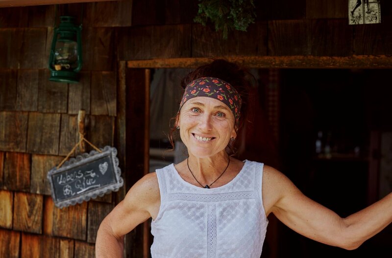 Martina ist Sennerin auf einer Alm im Mangfallgebirge. Zusammen mit ihrem Partner Andi kümmert sie sich um 140 Rinder, 30 Ziegen, 2 Ponys und eine Schar Hühner. Martina stammt aus einem kleinen Milchviehbetrieb im oberbayerischen Chiemgau. Gelernt hat sie Krankenschwester. Als sie zum ersten Mal auf die Alm zog, wusste sie nicht, wie sehr diese Entscheidung ihr Leben auf den Kopf stellen würde. Denn die Alm ist für Martina weit mehr als ein Beruf. – Bild: BR/​megaherz gmbh/​Melina Hehemeyer