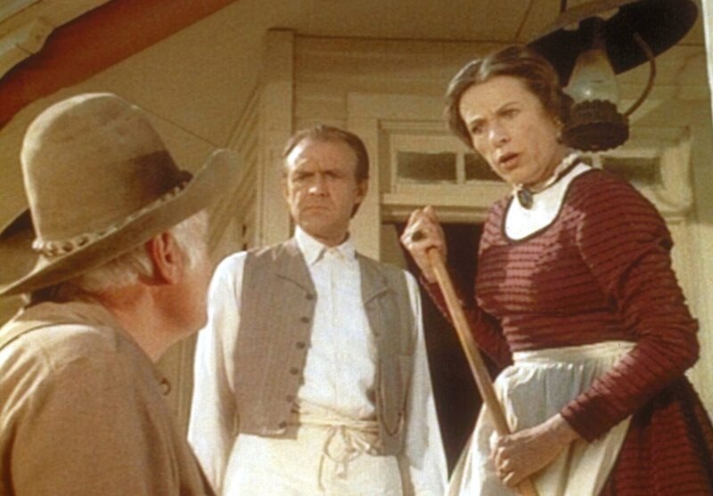 Mrs. Oleson (Katherine MacGregor, r.) und Mr. Oleson (Richard Bull, M.) dulden es nicht länger, dass der Farmer Holbrook (John Alderson, l.) ihren Eingang blockiert. – Bild: Worldvision
