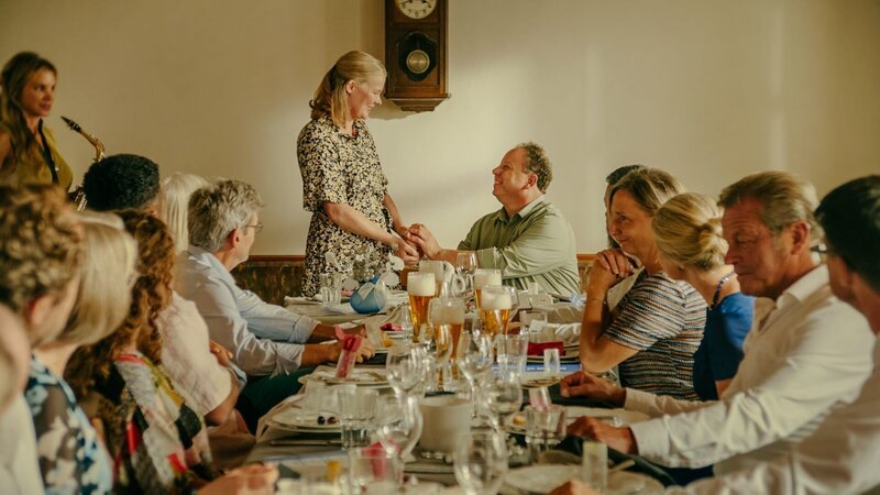 Ein besonderer Moment bei der Silbernen Hochzeit von Anneliese Eisele (Helga Reichert, M.) und Wolfram Eisele (Roberto Martinez, 5.v.r.). Während sich das Paar rührend die Hände hält, sorgt Tante Gabi (Nina Gnädig, l.) musikalisch für die passende Stimmung. – Bild: ZDF und © Conrad Lobst