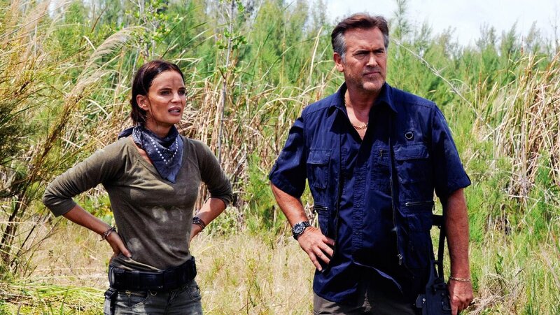Fiona Glenanne (Gabrielle Anwar) und Sam Axe (Bruce Campbell) verfolgen einen Verdächtigen bis in ein hochgesichtertes Militärcamp. – Bild: RTL /​ USA Network