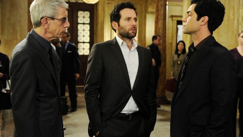 Sergeant Munch (Richard Belzer, l.) und Nick Amaro (Danny Pino, r.) beschäftigen sich mit einem verzwickten Fall: Auf einem Konzert wird ein Mädchen Opfer eines sexuellen Übergriffs. Der Sicherheitsmann Frank Patterson (Eion Bailey) wird Zeuge der Tat und behauptet, er habe versucht dem Mädchen zu helfen. Doch sie hingegen sagt, er gehört zu dem Kreis der Täter. Was hat sich auf dem Konzert wirklich zugetragen? – Bild: RTL /​ NBC Universal