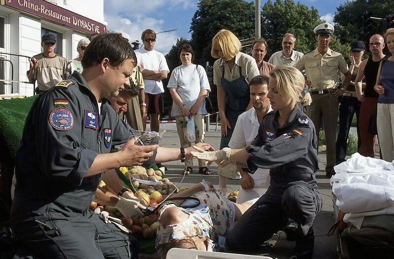 Vor dem Laden von Sabines Mutter versorgen Thomas und Sabine Gabi Wittmann, die bei der Hitze mit einem Kreislaufkollaps zusammen gebrochen ist. (vorn v.l.n.r.: Ulrich Bähnk, Heidrun Gärtner, Marlene Marlow) – Bild: Boris Laewen