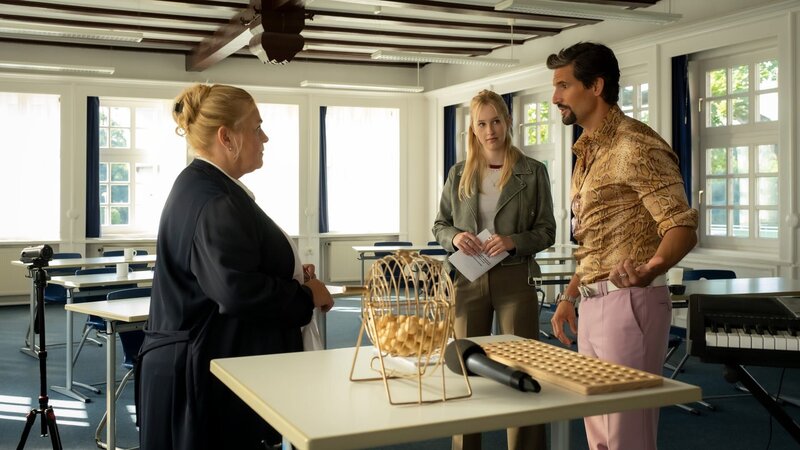 Dörte (Petra Kleinert, l.) und Anastasia (Luise Emilie Tschersich, M.) befragen Bingo Jürgen (Tom Beck), ob ihm bei seiner heutigen Show irgendetwas aufgefallen ist? – Bild: ZDF und Conny Klein