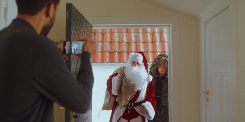 Andi (Milan Peschel, M.) und Rocco (Hoang Minh Ha, r.) spielen Weihnachtsmann und Knecht Ruprecht für Theo (Benito Bause, l.) und Familie Sawadi-Kröger. – Bild: ZDF und Zamarin Wahdat