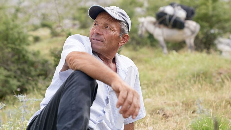 Bastri Limoj gönnt sich beim Aufstieg auf die Hochalm eine Verschnaufpause. – Bild: Arte