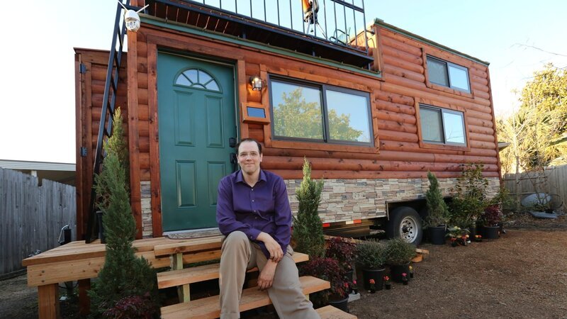 Chad smiles and poses for the camera on the front steps of his completed tiny home, equipped with many smart and automated technology features, in Plano, Texas, as seen on Tiny House, Big Living. – Bild: DIY Network/​Scripps Networks, LLC