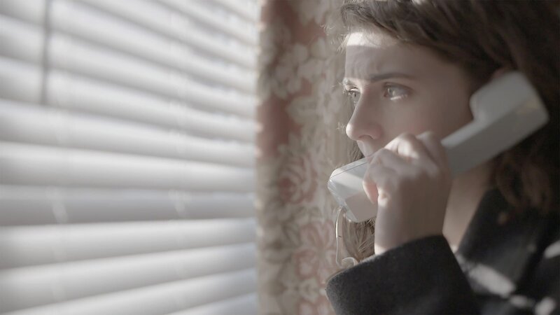 A woman is on the phone looking out the window. – Bild: Investigation Discovery /​ Discovery Communications