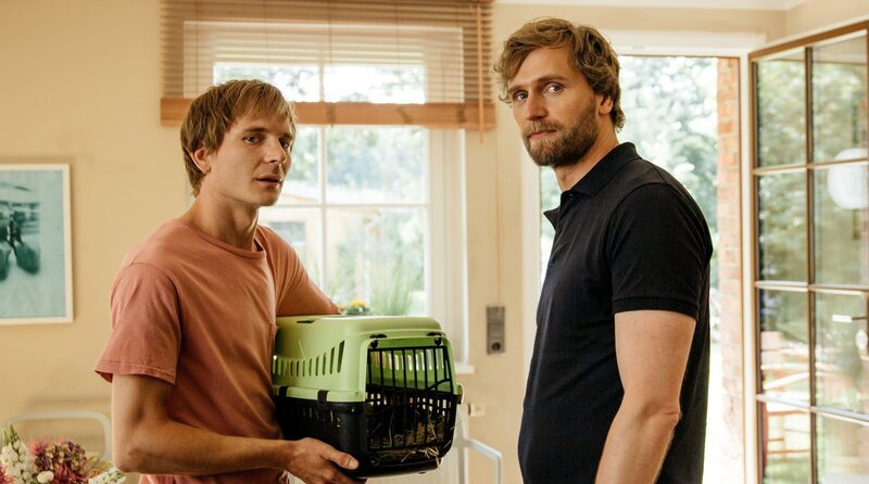 Jesse (Titus Kraus, li.) besucht die Tierarztpraxis von Eric (Ulrich Brandhoff, re.) nicht nur wegen seines kranken Kaninchens. – Bild: ARD Degeto/​Andrea Hansen