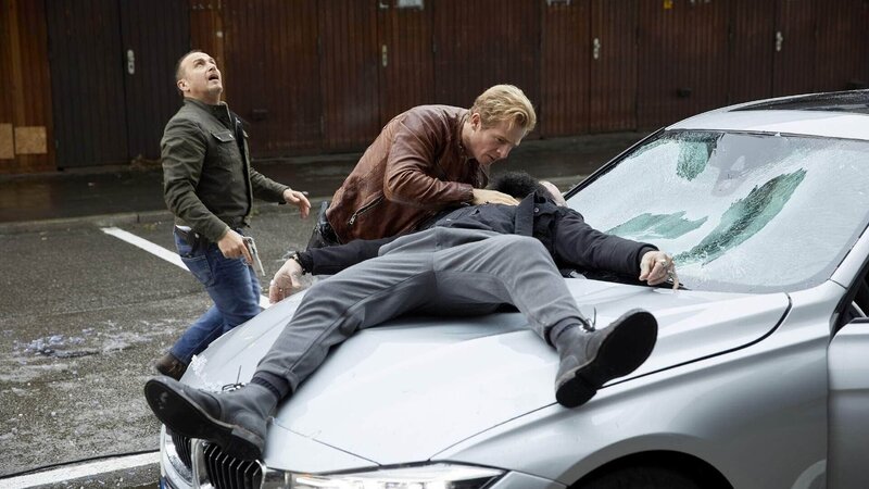 Semir (Erdogan Atalay, l.) und Paul (Daniel Roesner) fällt ein Hehler auf die Motorhaube. Dessen letzte Worte führen sie auf der Suche nach den Killern. – Bild: TVNOW /​ Guido Engels