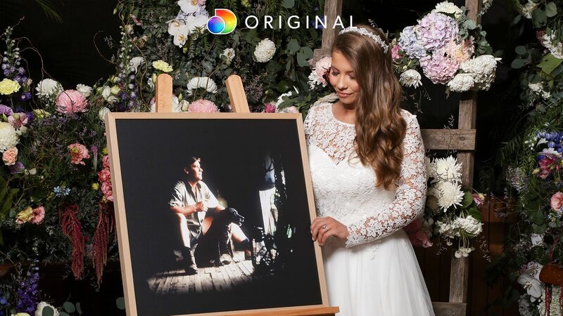 Bindi Irwin standing next to an easel with a photo of her father Steve Irwin – Bild: Discovery Communications, LLC