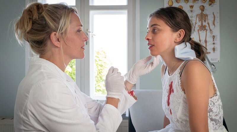 Nora (Tanja Wedhorn) behandelt Emilia (Lene Oderich) nach einem Strandunfall. – Bild: ARD Degeto/​Boris Laewen /​ ZDF und ARD Degeto/​Boris Laewen