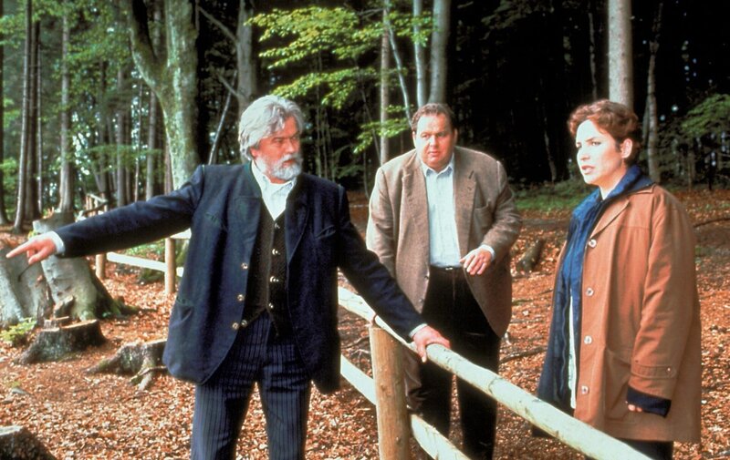 „Der Bulle von Tölz – Treibjagd“, Zwei Holzarbeiter finden in der idyllischen Jachenau die Leiche eines Jägers. Die Ermittlungen führen Benno und Sabrina zu Bauunternehmer Rampold. Dieser plant in besagter Au ein exklusives Jagderlebniszentrum. Die meisten Bewohner der Jachenau wollen ihren Grund nicht verkaufen, doch mit Hilfe von Schmiergeldern hat sich Rampold die Mitarbeit von drei Bauern und dem Bürgermeister gesichert. Der Fall gestaltet sich äußerst schwierig, da die Dorfbewohner aus Angst um ihre Existenz nicht besonders kooperativ sind.Im Bild (v.li.): Wolfram Kunkel (Johann Mayr), Ottfried Fischer (Benno Berghammer), Katerina Jacob (Sabrina Lorenz). – Bild: ORF/​Kineos