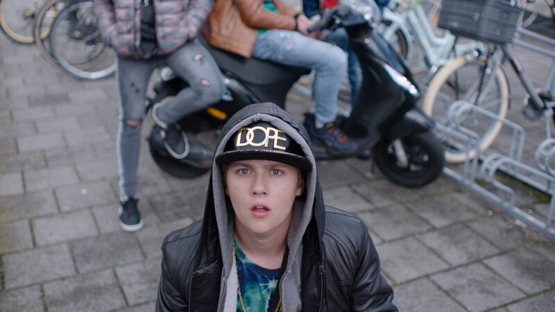 Kees (Ole Kroes) wird dabei erwischt, wie er auf dem Schulgelände etwas verkauft. – Bild: NDR/​NL Film