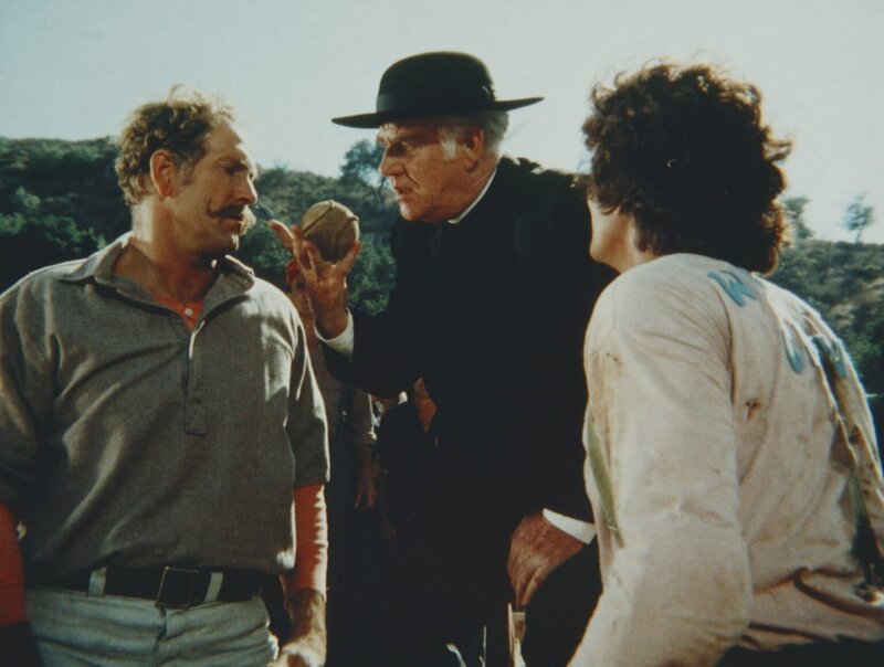 Slick McBurney (Gregory Walcott, l.) wird vom Schiedsrichter, Reverend Alden (Dabbs Greer), verwarnt, weil er unfair gespielt hat. Charles (Michael Landon, r.) verfolgt das ganze mit Genugtuung. – Bild: Worldvision Lizenzbild frei