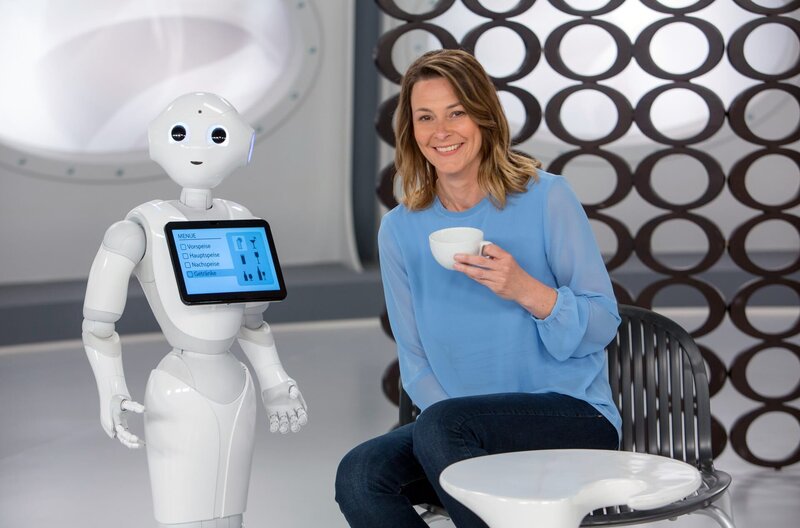 In Japan wird ein Versuchs-Kaffee betrieben, in dem Roboter kellnern. So weit, so normal!. Das Besondere: Die Roboter sind keine autonom agierenden Maschinen, sondern werden von Menschen ferngesteuert, die aufgrund von Krankheit oder Behinderung ans Bett gefesselt sind. Wie das funktioniert und welchen besonderen Nutzen ein solches Roboter-Kaffee hat, erklärt Anja Reschke in „Wissen vor acht – Zukunft“. – Bild: ARD/​Michael Boehme