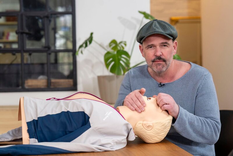 Doc Esser führt an einer Reanimationspuppe vor, wie man eine Mund-zu- Mundbeatmung durchführt. – Bild: WDR/​Solis TV/​Melanie Grande