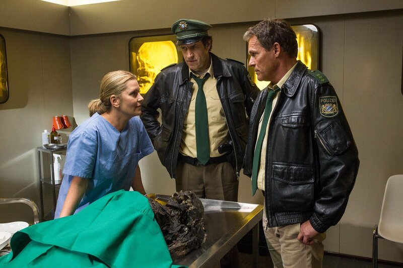 Dr. Anja Licht (Karin Tahler, l.) erläutert Hubert (Christian Tramitz, r.) und Staller (Helmfried von Lüttichau, M.) ihre Erkenntnisse nach der Untersuchung des verbrannten Torso. Es handelt sich um eine verbrannte Frau im Alter von 18 bis 30, die vorher erwürgt wurde. – Bild: ARD/​TMG, Chris Hirschhäuser