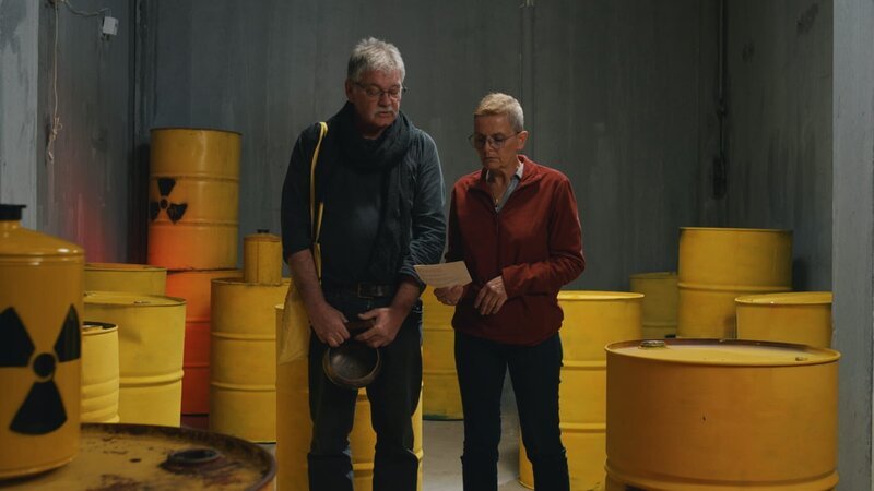 Die Anti-Atom-Aktivisten Tom und Carola lesen den Text einer Mahnwache aus dem Jahr 1990 vor. Seit Jahrzehnten halten sie wöchentlich Mahnwachen vor dem Kraftwerk Gundremmingen ab, um gegen die Kernkraft zu protestieren. – Bild: ZDF Die Anti-Atom-Aktivisten Tom und Carola lesen den Text einer Mahnwache aus dem Jahr 1990 vor. Seit Jahrzehnten halten sie wöchentlich Mahnwachen vor dem Kraftwerk Gundremmingen ab, um gegen die Kernkraft zu protestieren. – Bild: ZDF