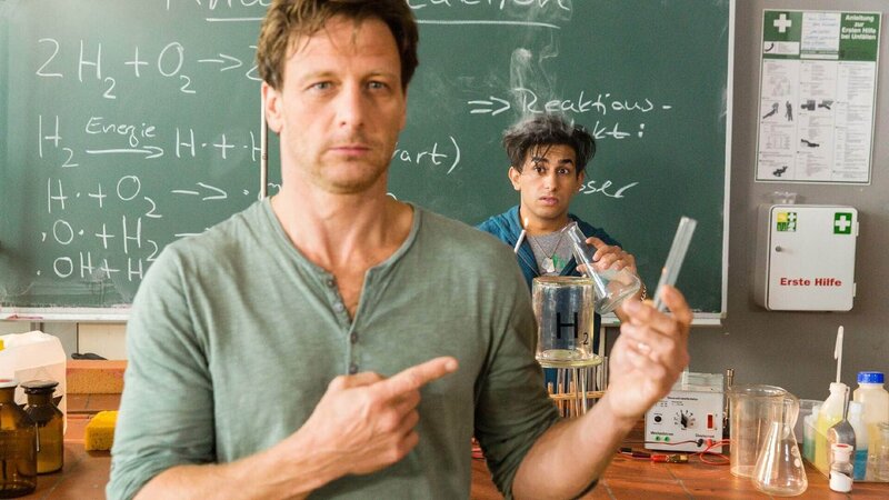 Stefan Vollmer (Hendrik Duryn, l.) macht die Knallgasprobe. Mehmets (Zeyhun Demirov) dampfen die Haare. – Bild: TVNOW /​ Frank Dicks