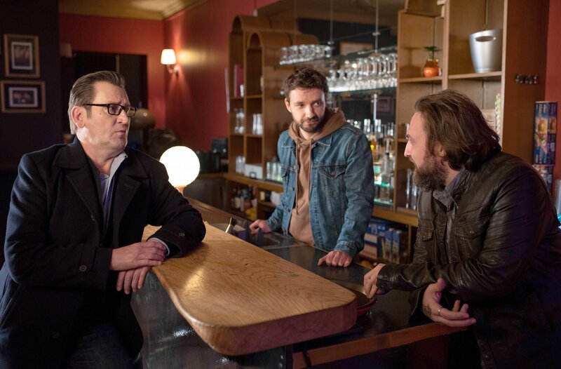 Die Kommissare Lars (Ingo Naujoks, l.) und Gregor (Jonas Minthe, M.) verhören den Lübecker Klubbetreiber Philip Yates (Johannes Kühn, r.). Er schuldete dem Mordopfer noch eine Menge Geld. – Bild: ARD/​Thorsten Jander