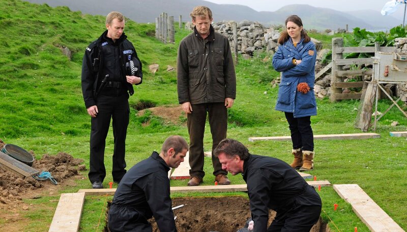 Zusammen mit seinen Kollegen Sandy Wilson (Steven Robertson, stehend li.) und Alison McIntosh (Alison O’Donnell, re.) kommt Detective Inspector Jimmy Perez (Douglas Henshall, Mitte) einem düsteren Geheimnis auf die Spur. – Bild: NDR/​Degeto/​ITV Studios