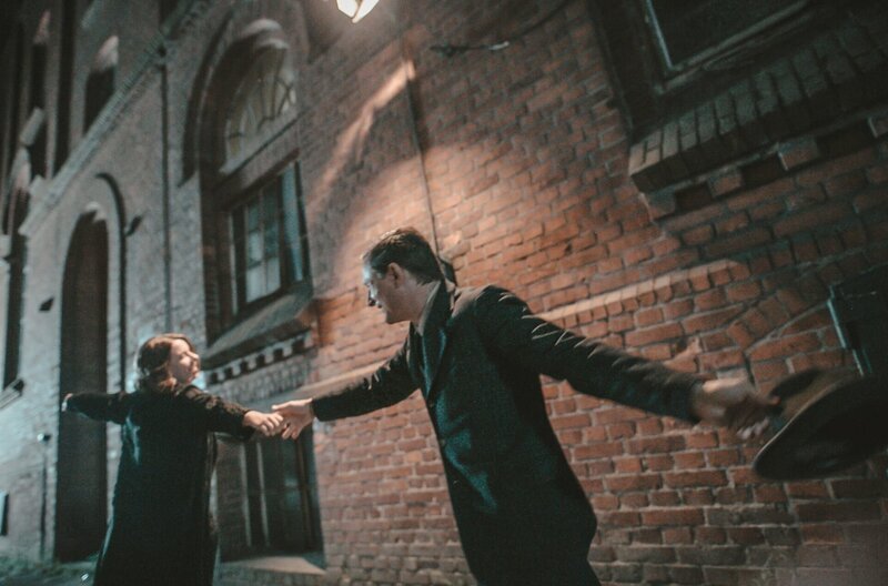 Schauspieler Alice Dwyer (links) und Florian Lukas (rechts) tanzen als Ehepaar Sonja Marchlewska und Heinrich Vogeler durch das nächtliche Bremen. – Bild: NDR/​Benjamin Eichler