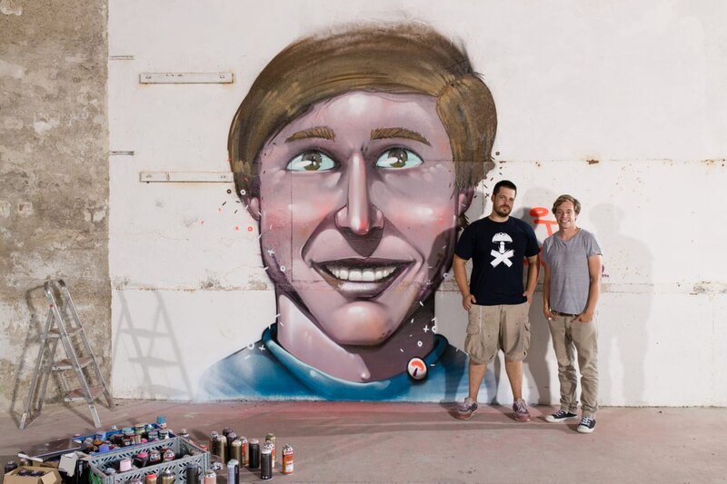 Checker Tobi mit Graffiti-Künstler Daniel Westermaier vor dem Graffiti. – Bild: BR/​megaherz GmbH/​Hans-Florian Hopfner
