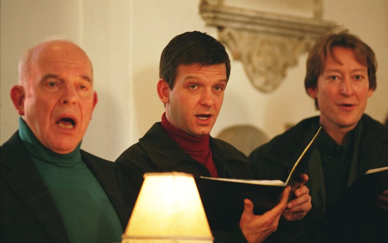 Constable Jones (Jason Hughes, M.) wurde in der Badewanne als passabler Tenor entdeckt. Seitdem probt er zwischen den beiden Mordverdächtigen Leo Clarke (John Shrapnel, l.) und Stephen Latimer (Scott Handy, r.). – Bild: ZDF