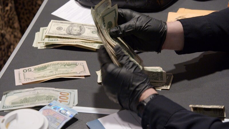 CBP-Beamte, die am Philadelphia International Airtport in Philadelphia nach nicht deklariertem Geld Ausschau halten, zählen Geldscheine. (National Geographic) – Bild: National Geographic /​ Disney