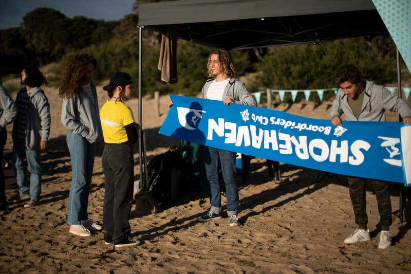 Die Shorehaven-Mannschaft mit Bodhi (Savannah La Rain, v.l.), Summer (Sky Katz, v.2.v.r.), Ari (Kai Lewins, 2.v.r.) und Marlon (Joao Marinho, r.) bereitet sich auf den Board Riders-Wettkampf vor. Sie treten gegen Clubs von überall aus dem Bundesstaat an und haben vor, besonders ihre Rivalen vom Anchor Cove-Team zu besiegen. – Bild: ZDF/​Ed Sloane