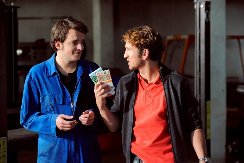 Bayerisches Fernsehen DAHOAM IS DAHOAM, FOLGE 822, „Schmutziges Geschäft“, Flori und Lex freuen sich über das erste gemeinsame Geld. Von links: Florian Brunner (Tommy Schwimmer) und Lex (Sebastian Gerold). – Bild: BR/​Marco Orlando Pichler