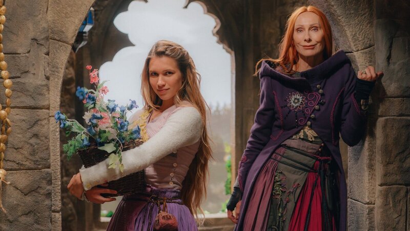 Rapunzel (Anna-Lena Schwing, l.) und die Zauberin Eleonor (Andrea Sawatzki, r.) stehen im hochgelegenen Zimmer des einsamen Turmes, in den sie sich wegen der Verfolgung durch die Königin geflüchtet haben. – Bild: Dusan Martincek