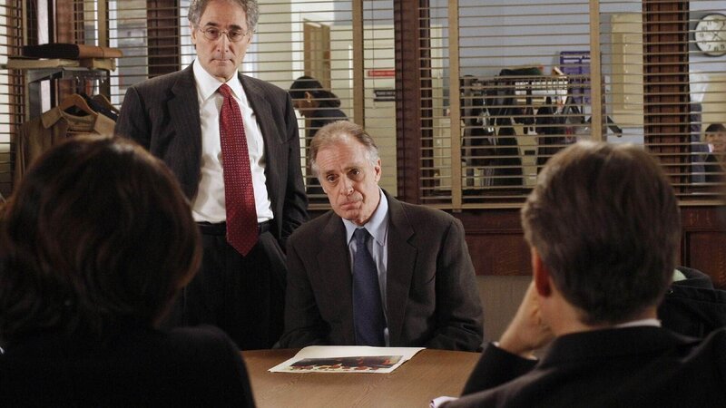 In Begleitung seines Anwaltes Vick (Stephen Singer, hi.li.) stellt sich Martin Garvik (Keith Carradine, Mi.) den Fragen der Ermittler zu dem chinesisch-amerikanischen Spionagefall, in den er verwickelt war. – Bild: TVNOW /​ NBC