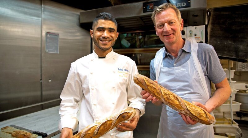 „Backe, backe Baguette“: Was dem Deutschen das Graubrot ist dem Franzosen sein Baguette. Das längliche Weißbrot ist hier fester Bestandteil einer jeden Mahlzeit. In Paris findet sogar ein Wettbewerb um das beste Baguette statt. Michael Kessler (r.) besucht den Sieger (l.) des Jahres und lässt sich von ihm in die Geheimnisse der Backkunst einweihen. – Bild: phoenix/​ZDF/​Oliver Halmburger