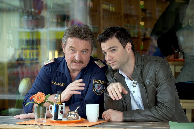 „Soko Kitzbühel“, „Auf Liebe und Tod.“ Nach einer nächtlichen Poker-Runde in den Pochlarner Stuben, an der auch Hannes teilnimmt, wird der Mechaniker Klaus Tauber erschossen. Tauber war allerdings im Auto seines Freundes Franz Spiegel unterwegs und wollte dessen Limousine vor der Villa des wohlhabenden Unternehmers abstellen. Spiegels Ehefrau Rita, eine gebürtige Portugiesin, hat gerade noch gesehen, wie jener Wagen, aus dem auf Tauber geschossen wurde, in der Dunkelheit verschwunden ist. Die SOKO ist sich ziemlich sicher: Es hat den Falschen erwischt. Über das Kennzeichen des beobachteten Wagens stoßen die Ermittler auf ein Escort-Service und dort auf Herbert Brunner, den mehrfach vorbestraften Chauffeur dieser „Agentur“, die „Modelle“ an betuchte Kunden zwischen Kitzbühel und München vermittelt. Wie Spiegel aber damit zusammenhängen könnte ist ein hartnäckiges Rätsel. Erst ein genauerer Blick in die Vergangenheit des Chauffeurs bringt die Ermittler auf eine Spur.Im Bild (v.li.): Ferry Öllinger (Kroisleitner), Jakob Seeböck (Lukas Roither). – Bild: ORF 1