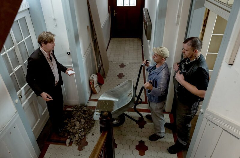 Huck (Patrick von Blume, l.) will im besetzten Mietshaus seines Mandanten Schlegel nach dem Rechten sehen. Schlegels Bauarbeiter Gilbert (Sven Thiemann, M.) und Matze (Andre Hofmann, r.) kippen ihm eine Fuhre Bauschutt auf die Füße. – Bild: SWR