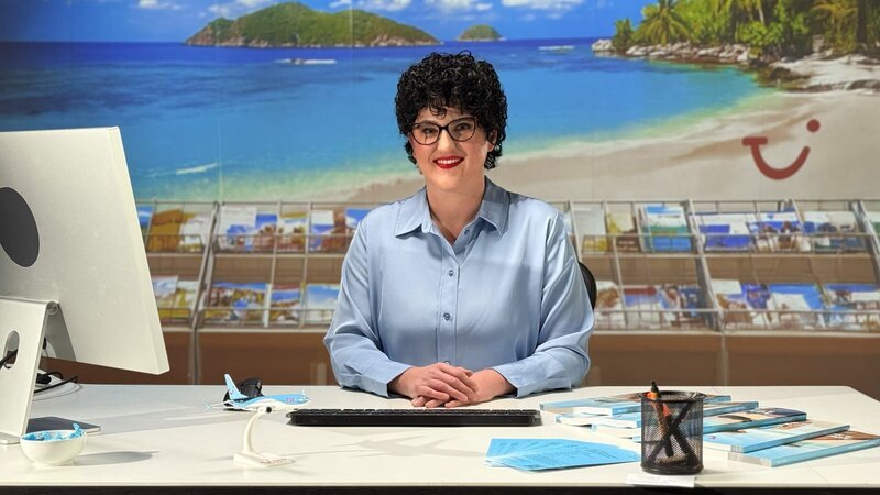 Verkäuferin im Reisebüro: Die Katalogsprache von TUI – teilweise zu schön, um wirklich wahr zu sein. – Bild: ZDF und Marvin Mohr