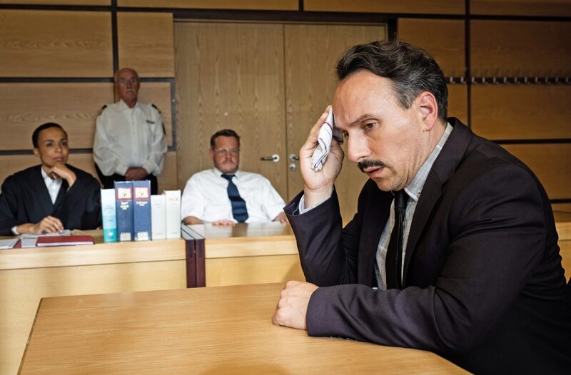 Carsten Heinrich (Stefko Hanushevsky, r.) muss im Fall Wolfgang Brink (Roland Riebeling, 2.v.r. mit Azizè Flittner, l. und Komparse), vor Gericht, Rede und Antwort stehen. – Bild: ARD/​Martin Valentin Menke
