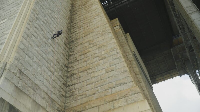 Ein Mitglied des Polizei-Rettungsteams klettert mit einem Seil die Wand hinunter. – Bild: Hat Trick International Limited