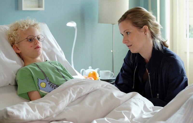 Der kleine Benno (Jimmy Gutzeit) vermisst seinen Vater und hofft, dass er wenigstens kommt, wenn er krank in der Klinik liegt. Manja Arnold (Teresa Weißbach) ist ratlos. – Bild: MDR/​Sebastian Kiss