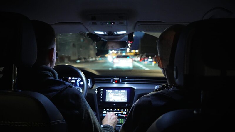 Polizeibeamte im Auto – Bild: Warner Bros. Discovery