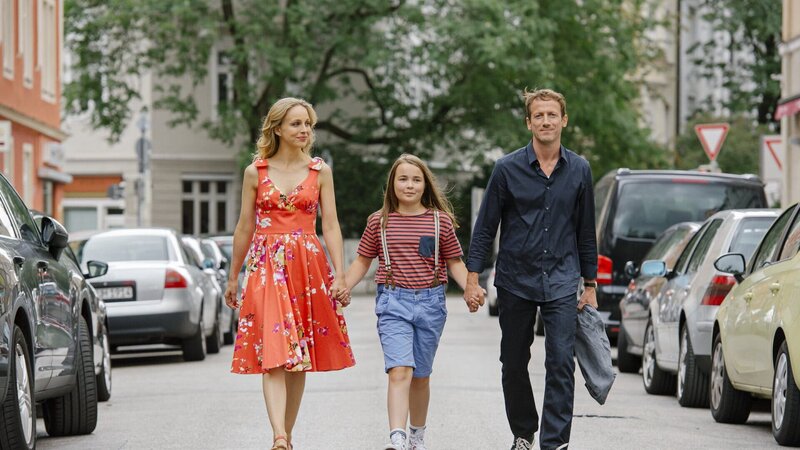 Julchen (Lara Sophie Rottmann, Mitte) hätte zwar am liebsten, dass Papa daheim wieder einzieht, aber da sie Mamas neuen Freund Gregor (Wotan Wilke Möhring) so mag und ihre Mama (Petra Schmidt- Schaller) mit ihm so glücklich ist, fühlt sie sich auch mit diesen „Eltern“ sehr wohl. – Bild: Marco Nagel