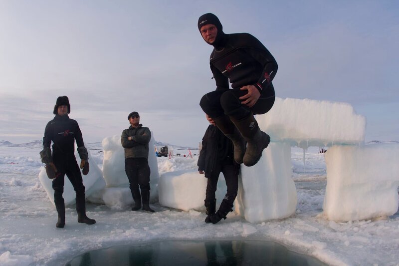 Zeke Tenhoff jumps into dive hole while John Bunce and Grant Wilkins look on. – Bild: Discovery Channel /​ Discovery Communications