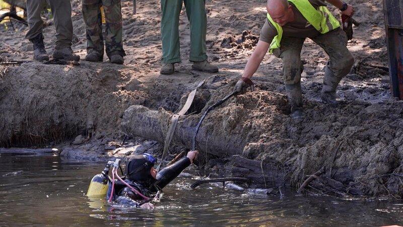 A diver emerges from the swamp. – Bild: Warner Bros. Discovery