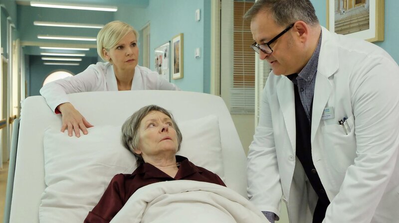 Dr. Kathrin Globisch (Andrea Kathrin Loewig, li.) muss Luise Brenner (Monika Lennartz, liegend) sofort operieren. Hans-Peter Brenners (Michael Trischan, re.) Mutter leidet an Krebs und hat einen akuten Darmverschluss. – Bild: Sebastian Kiss